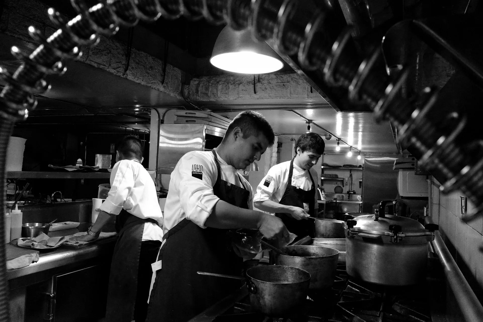 Chefs trabajando en una cocina profesional, en blanco y negro